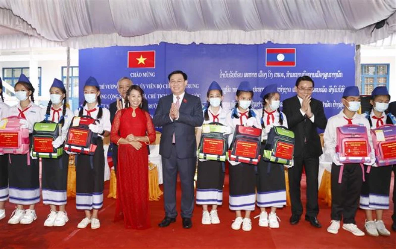Chủ tịch Quốc hội Vương Đình Huệ tặng quà cho các cháu học sinh giỏi tại Trường phổ thông Dân tộc nội trú tỉnh Champasak (Lào), chiều 17/5. (Ảnh: TTXVN)