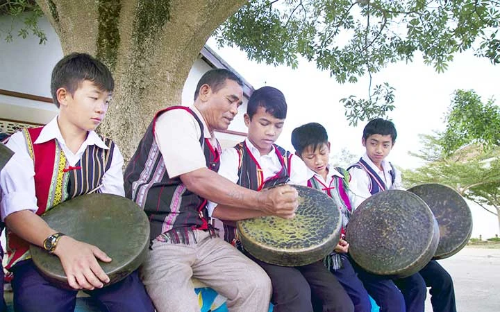 Già làng truyền dạy cách đánh cồng chiêng cho thế hệ trẻ.