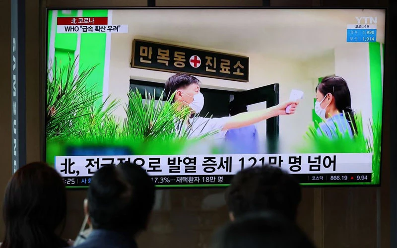 Từ một nhà ga của Hàn Quốc, người dân theo dõi bản tin về tình hình dịch Covid-19 tại Triều Tiên. (Ảnh: Reuters)