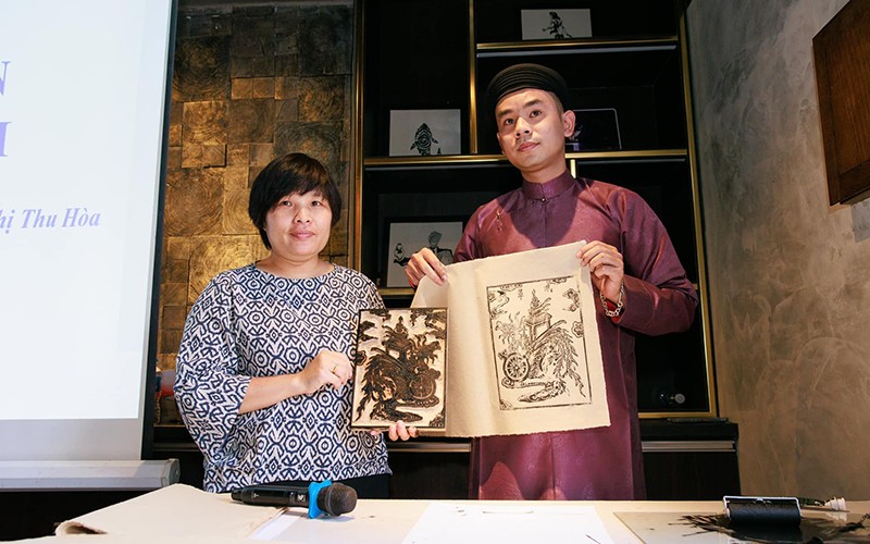 Nhà nghiên cứu Nguyễn Thị Thu Hòa (bên trái) giới thiệu một mẫu tranh đồ thế.