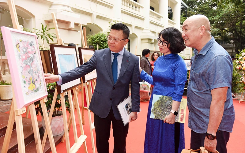 Tổng Biên tập Báo Nhân Dân Lê Quốc Minh thăm triển lãm Tranh trên báo cũ. Ảnh: TRẦN HẢI