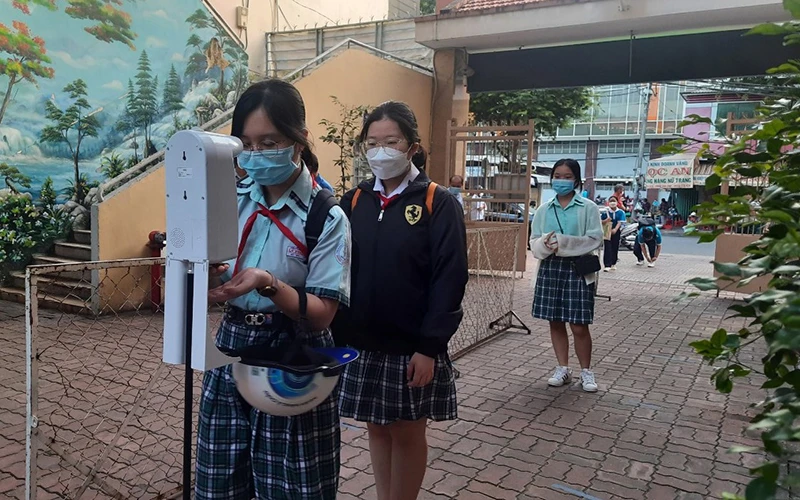 Học sinh Trường trung học cơ sở Lý Phong, quận 5, Thành phố Hồ Chí Minh kiểm tra thân nhiệt, sát khuẩn tay trước khi vào học (thời điểm dịch Covid-19 đang diễn ra phức tạp).
