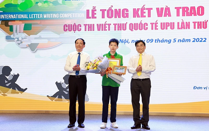 Ban tổ chức trao giải nhất cuộc thi viết thư quốc tế UPU lần thứ 51 cho em Nguyễn Bình Nguyên, lớp 9A1, Trường THCS Nguyễn Tri Phương, quận Ba Đình (Hà Nội). (Ảnh Thùy Dương)