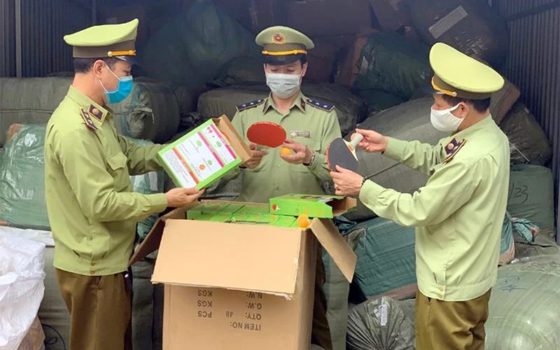 Lực lượng Quản lý thị trường tỉnh Lạng Sơn kiểm tra số hàng nghi nhập lậu tại Bưu cục Tân Thanh. (Ảnh BÙI NỤ)