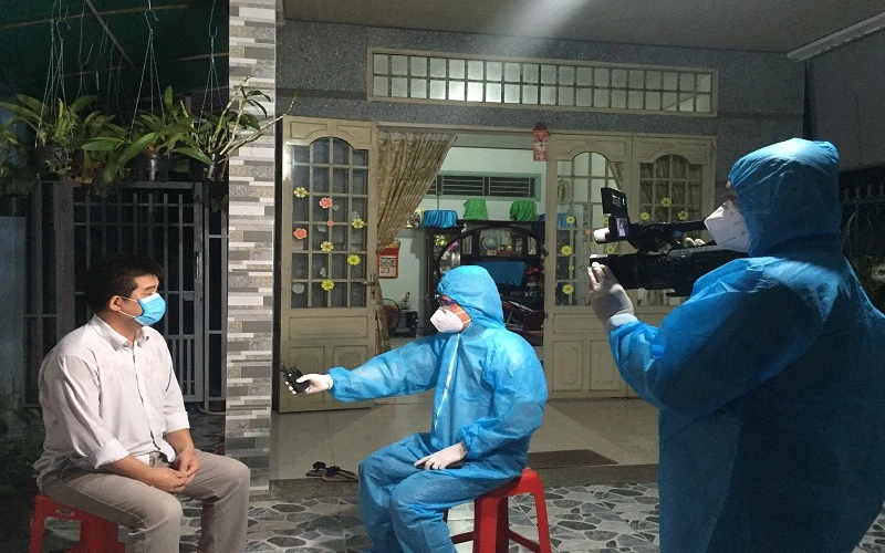 Phóng viên truyền hình Quốc phòng Việt Nam tác nghiệp trong tâm dịch Covid-19.