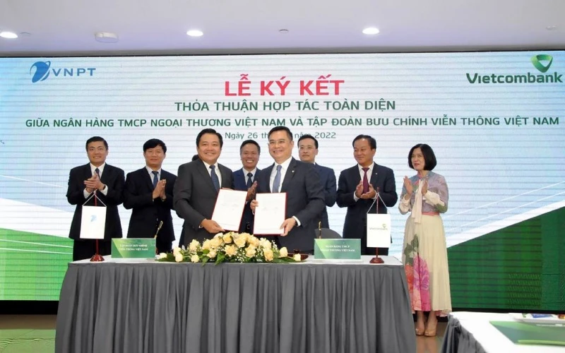 Tổng Giám đốc VNPT Huỳnh Quang Liêm và Phó Tổng Giám đốc Phụ trách Ban điều hành Vietcombank Nguyễn Thanh Tùng trao Bản ký kết thỏa thuận hợp tác toàn diện giữa hai đơn vị.