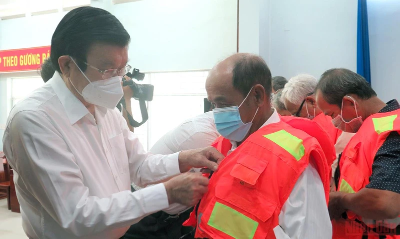 Nguyên Chủ tịch nước Trương Tấn Sang trao áo phao cứu sinh cho ngư dân.