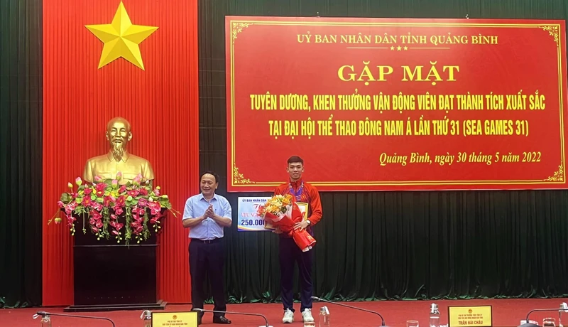 Phó Bí thư Thường trực Tỉnh ủy Quảng Bình Trần Hải Châu trao thường và tặng hoa cho Nguyễn Huy Hoàng.