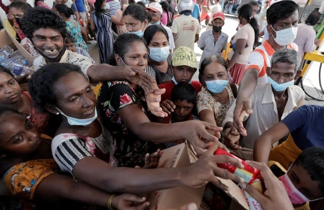 Người dân Sri Lanka nhận hàng hóa viện trợ. (Ảnh: Reuters/TTXVN)