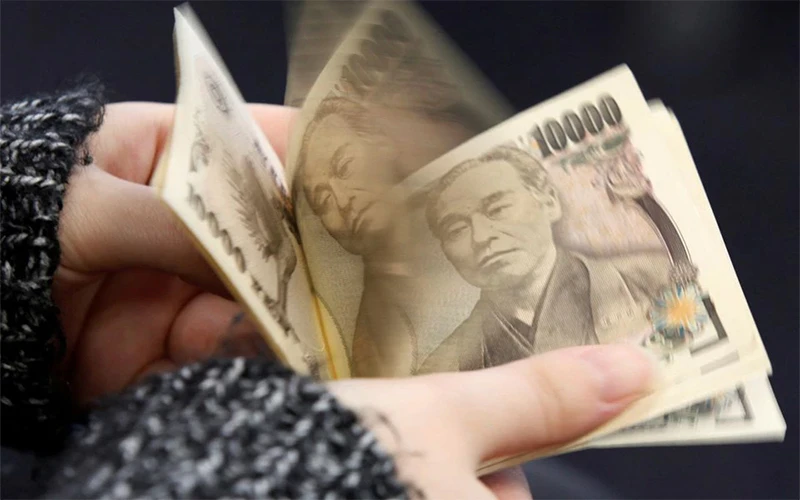 Người phụ nữ đang đếm tờ 10.000 yen tại Tokyo. (Ảnh: Reuters)