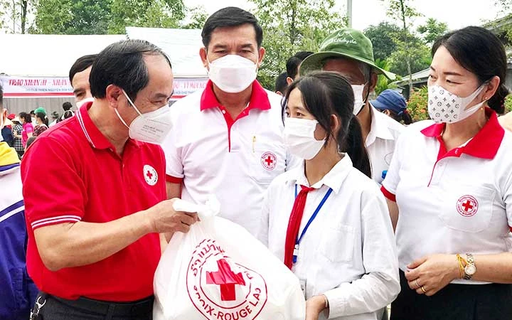 Đại diện Hội Chữ thập đỏ tỉnh Thanh Hóa trao quà tặng học sinh có hoàn cảnh đặc biệt khó khăn vươn lên trong học tập tại lễ phát động Tháng Nhân đạo năm 2022. (Ảnh: LÊ LINH)