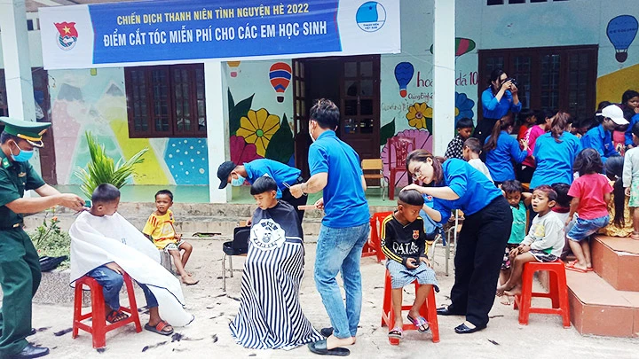 Bộ đội và thanh niên cắt tóc cho các em nhỏ trên cổng trời Cha Lo.