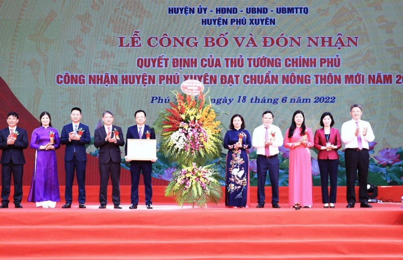 Lãnh đạo huyện Phú Xuyên đón nhận Quyết định của Thủ tướng Chính phủ công nhận huyện đạt chuẩn nông thôn mới năm 2020. (Ảnh: Ngọc Anh)