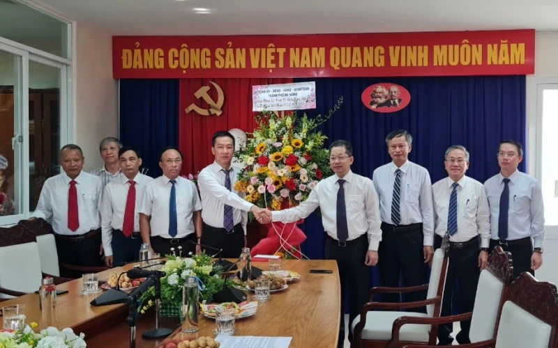 Đồng chí Nguyễn Văn Quảng tặng hoa chúc mừng cán bộ phóng viên Cơ quan Thường trực Báo Nhân Dân tại Đà Nẵng.