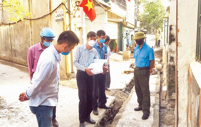 Chủ tịch Ủy ban MTTQ xã Đa Tốn Nguyễn Văn Đà (thứ ba từ trái sang) giám sát công trình xây dựng trên địa bàn.