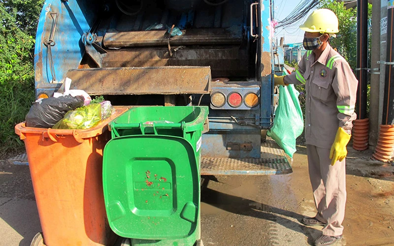 Công nhân Công ty cổ phần Đô thị Tân An, tỉnh Long An thu gom, vận chuyển rác thải. (Ảnh KIM NGÂN)