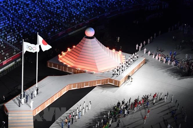 Quốc kỳ Nhật Bản (phải) và cờ Olympic tại lễ khai mạc Olympic Tokyo 2020 ở Tokyo, Nhật Bản, ngày 23/7/2021. (Ảnh: TTXVN)