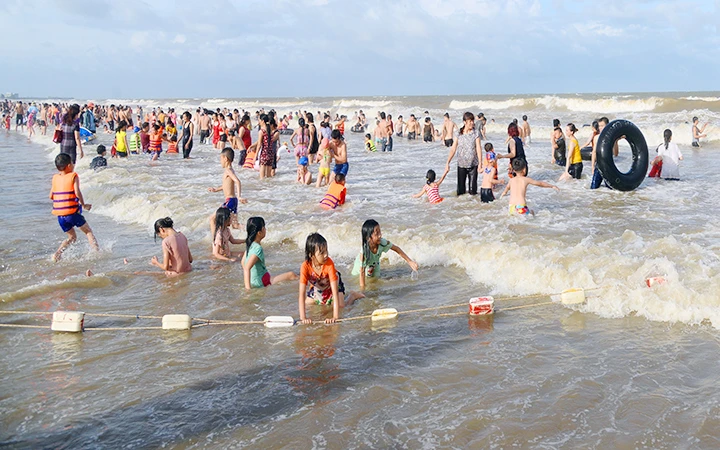 Bãi biển Sầm Sơn (tỉnh Thanh Hóa) thu hút đông du khách trong kỳ nghỉ hè. (Ảnh MINH HUYỀN)