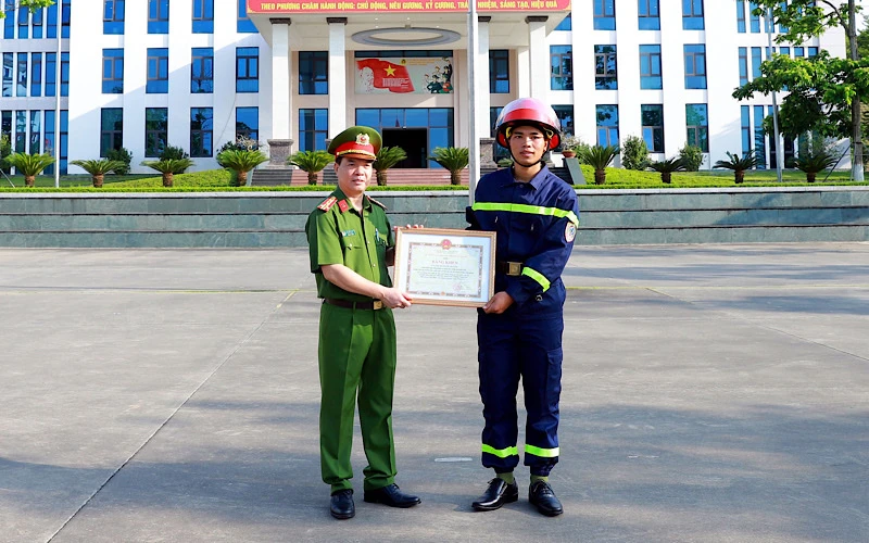 Đại tá Đỗ Tiến Thuỳ, Phó Giám đốc Công an tỉnh Tuyên Quang trao Bằng khen của Chủ tịch UBND tỉnh cho chiến sỹ Quan Ngọc Hoàng.