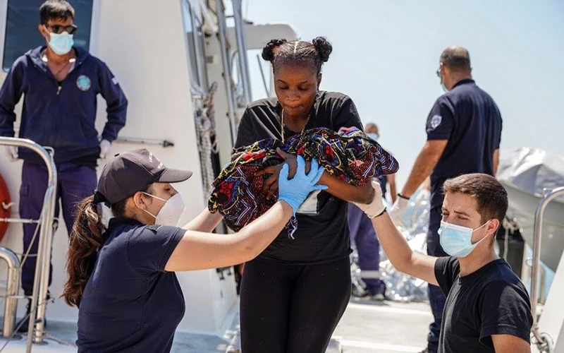 Lực lượng bảo vệ bờ biển Hy Lạp giải cứu một trẻ sơ sinh, con của người di cư trái phép. (Ảnh AP)