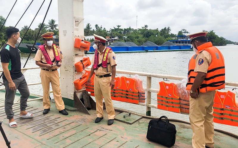 Công an tỉnh Vĩnh Long kiểm tra các phương tiện đường thủy tại bến phà Tân Nguyên Phú, huyện Tam Bình. (Ảnh MỘNG KHA)