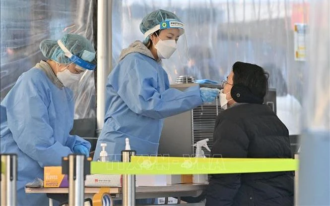 Nhân viên y tế lấy mẫu xét nghiệm Covid-19 cho người dân tại Seoul, Hàn Quốc. (Ảnh: AFP/TTXVN)