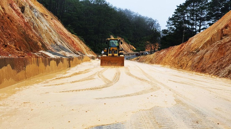Xe ủi được huy động để san phần bùn, đất sạt lở xuống Quốc lộ 24, đoạn qua xã Đăk Ring, huyện Kon Plông