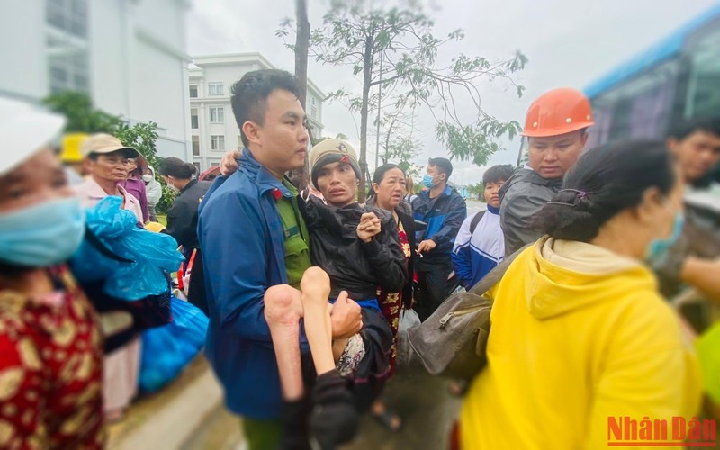 Công an xã Bình Đông đưa người bệnh từ nơi trú bão lên xe ô-tô để về nhà.