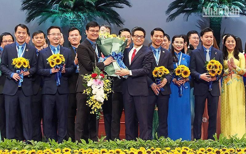 Phó Thủ tướng Vũ Đức Đam trao những bó hoa tươi thắm tặng Bí thư thứ nhất Trung ương Đoàn khóa XII Bùi Quang Huy và các đồng chí trong Ban Chấp hành Trung ương Đoàn khóa XII.