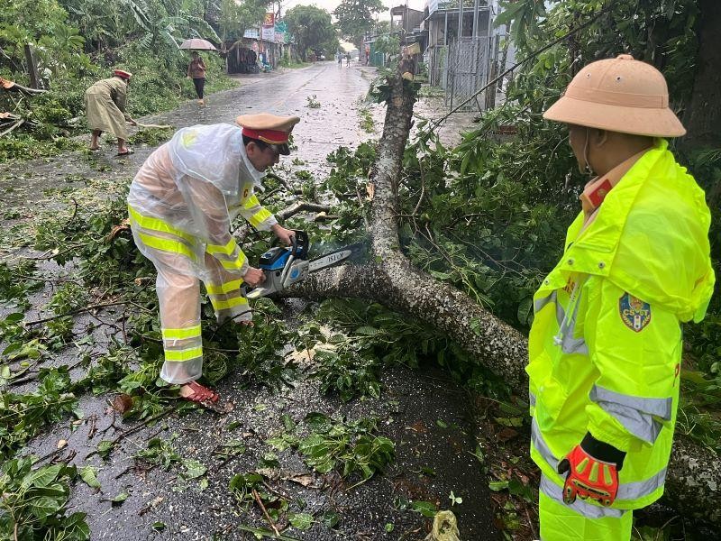 Lực lượng công an tỉnh Quảng Ngãi thu dọn cây xanh ngã đổ trên tuyến quốc lộ 24B.