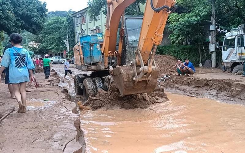 Lực lượng chức năng san gạt bùn đất do lũ quét để sớm thông quốc lộ 7, đoạn qua thị trấn Mường Xén (Kỳ Sơn).