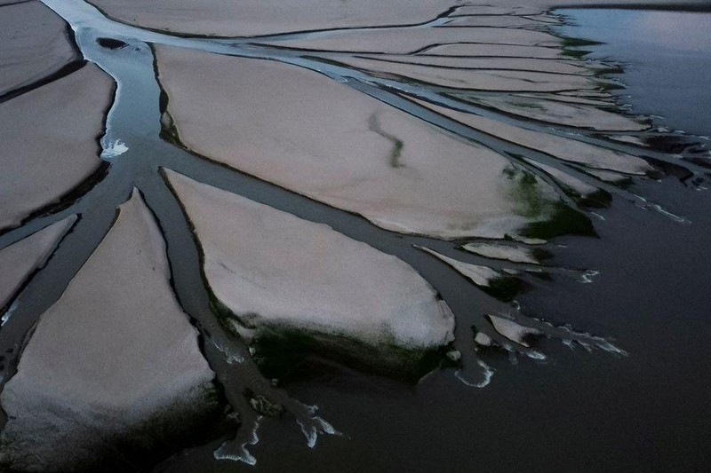 Ảnh chụp từ trên không ngày 28/8 cho thấy một dòng nhánh chảy qua các mảnh đất khô cạn của hồ Poyang, tỉnh Giang Tây, Trung Quốc. Ảnh: Reuters. 