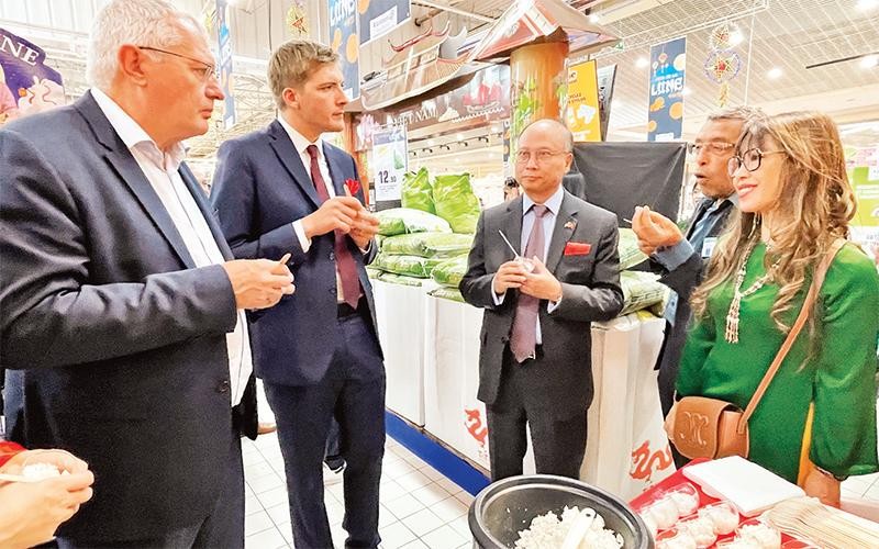 Các đại biểu nếm thử cơm Việt Nam tại siêu thị của Pháp. (Ảnh TTXVN) 
