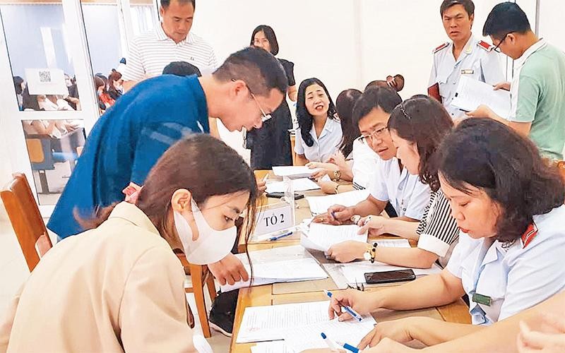 Đại diện các đơn vị nợ đóng bảo hiểm xã hội ký nhận quyết định công bố thanh tra của Thanh tra thành phố Hà Nội. (Ảnh THU HIỀN) 