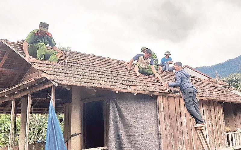 Công an xã Ba Lế, huyện Ba Tơ (Quảng Ngãi) giúp người dân sửa sang lại nhà hư hỏng do bão. 