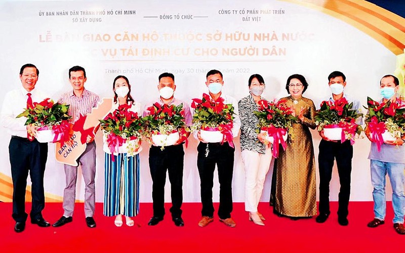 Chủ tịch Ủy ban nhân dân Thành phố Hồ Chí Minh Phan Văn Mãi (ngoài cùng bên trái) tặng nhà tái định cư cho người dân tại dự án số 100, đường Cô Giang, Quận 1. 