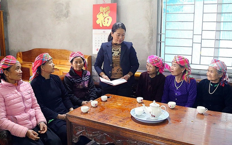 Bí thư Chi bộ thôn Én 2 (xã Khánh Yên Trung, huyện Văn Bàn) Lương Thị Ðồng vận động phụ nữ cao tuổi trong thôn thực hiện nếp sống văn hóa mới. (Ảnh PHẠM SƠN) 