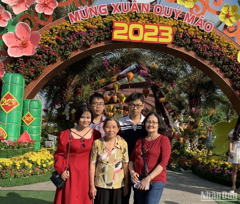 Gia đình chụp ảnh lưu niệm tại vườn hoa Xuân sáng mùng 2 Tết.