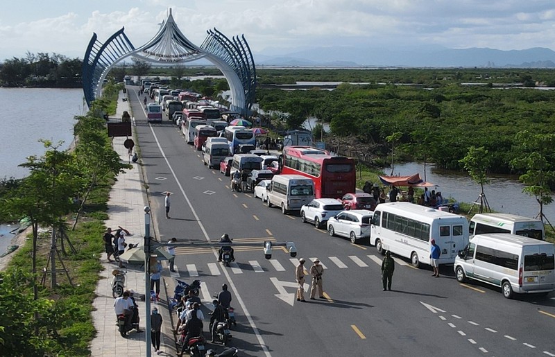 Ô tô chở khách du lịch tham quan đảo Cát Bà xếp hai hàng chạy dài hơn 1 km trên đường tỉnh 356 tại đầu bến Cái Viềng, chờ đến lượt xuống phà trở về đất liền. Ảnh : Báo Thanh Niên 