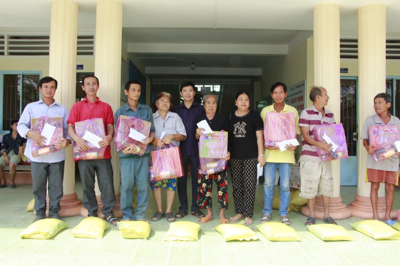 Lãnh đạo huyện Long Hồ và các nhà hảo tâm hỗ trợ tiền, quà cho người dân có nhà đất bị sạt lở.