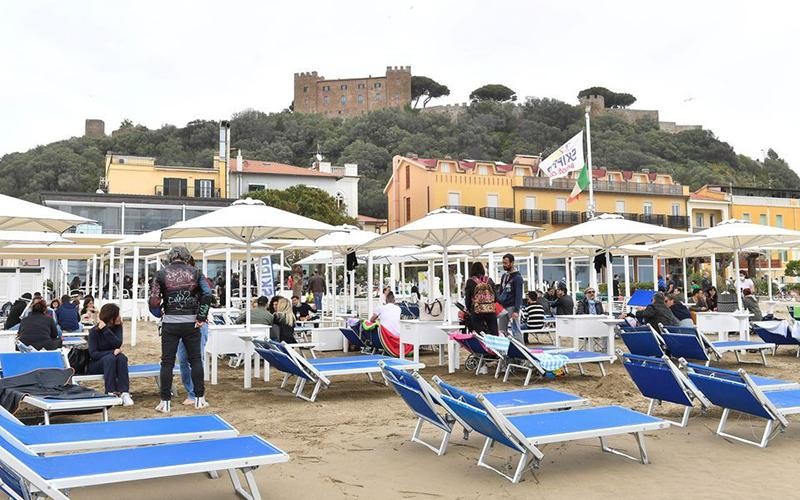 Du khách tận hưởng kỳ nghỉ ở một bãi biển tại Italia. (Ảnh REUTERS)