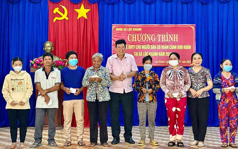 Đại diện Bảo hiểm xã hội tỉnh Bình Phước trao thẻ bảo hiểm y tế tặng người dân có hoàn cảnh khó khăn tại xã Lộc Khánh, huyện Lộc Ninh. (Ảnh THU CÚC)