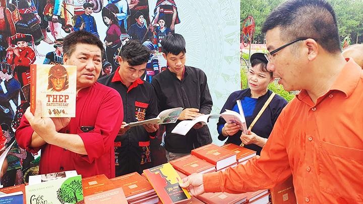 Ban nhà văn trẻ - Hội Nhà văn Việt Nam phối hợp tặng sách cho đồng bào tại Làng Văn hóa - Du lịch các dân tộc Việt Nam. Ảnh: QUANG HƯNG