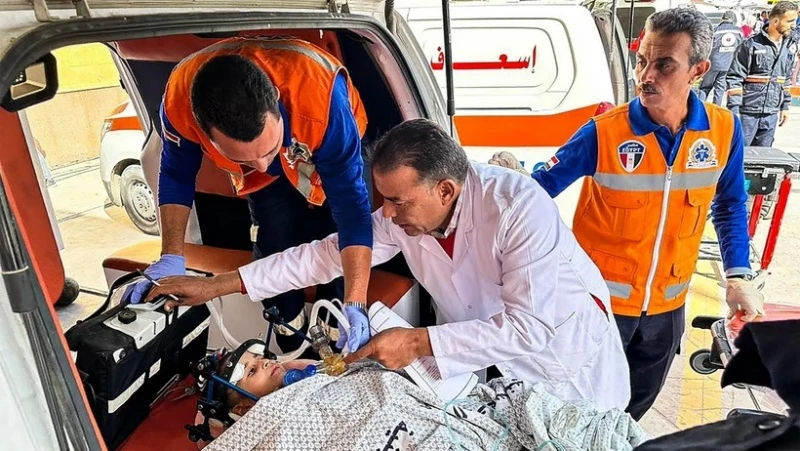 Nhân viên y tế Ai Cập chuyển một em nhỏ Palestine bị thương tới cửa khẩu biên giới với Gaza ở Rafah, ngày 27/11/2023. (Ảnh: AFP/TTXVN)