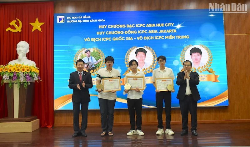 Phó Giáo sư, Tiến sĩ Lê Thành Bắc, Phó Giám đốc Đại học Đà Nẵng và Phó Giáo sư, Tiến sĩ Nguyễn Hữu Hiếu, Hiệu trưởng trường Đại học Bách khoa trao Giấy khen vinh danh các sinh viên xuất sắc. (Ảnh ANH ĐÀO)