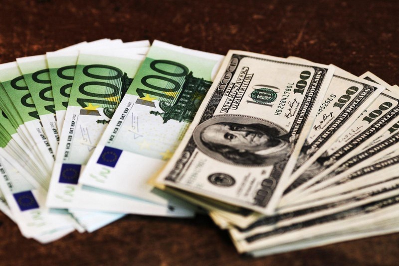 Đồng tiền giấy mệnh giá 100 euro (trái) và 100 USD. (Ảnh: AFP/TTXVN)
