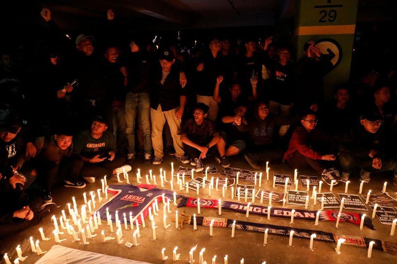 Các cổ động viên bóng đá và người dân Indonesia tổ chức buổi cầu nguyện tại sân vận động Patriot Candrabhaga, ngoại ô Jakarta, Indonesia, ngày 3/10/2022, để tưởng niệm các nạn nhân thiệt mạng trong vụ bạo loạn và giẫm đạp tại sân Kanjuruhan. (Ảnh: Reuters)