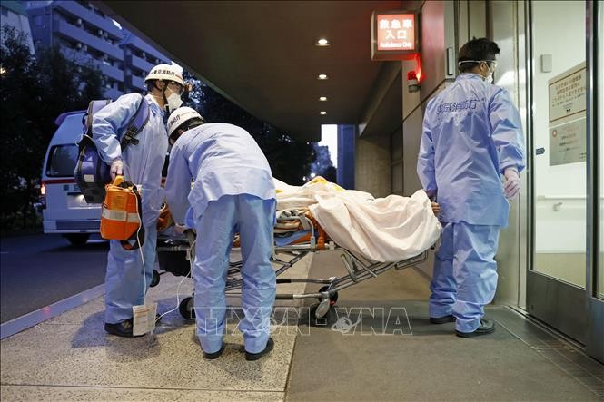 Nhân viên y tế chuyển bệnh nhân mắc Covid-19 tới bệnh viện tại Tokyo, Nhật Bản, ngày 1/2/2022. (Ảnh: Kyodo/ TTXVN)
