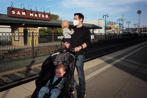 Người dân đeo khẩu trang phòng dịch Covid-19 tại ga tàu hỏa ở San Mateo, bang California (Mỹ). (Ảnh: THX/TTXVN)