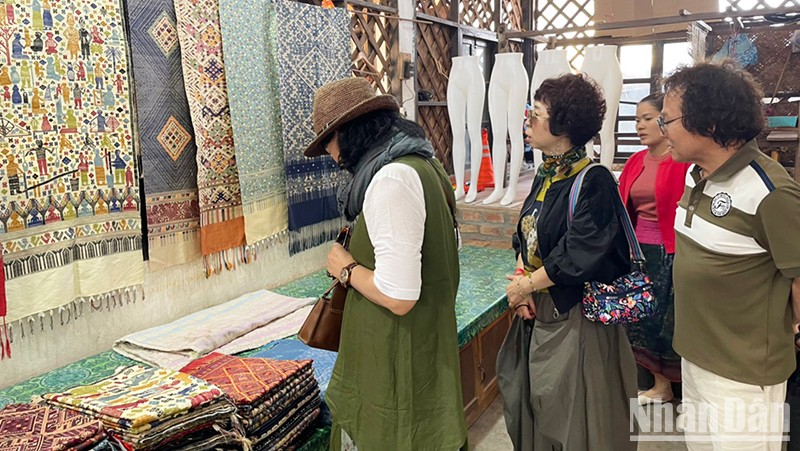 Du khách tham quan gian hàng bày bán vải thủ công của Lào. (Ảnh: Hải Tiến)